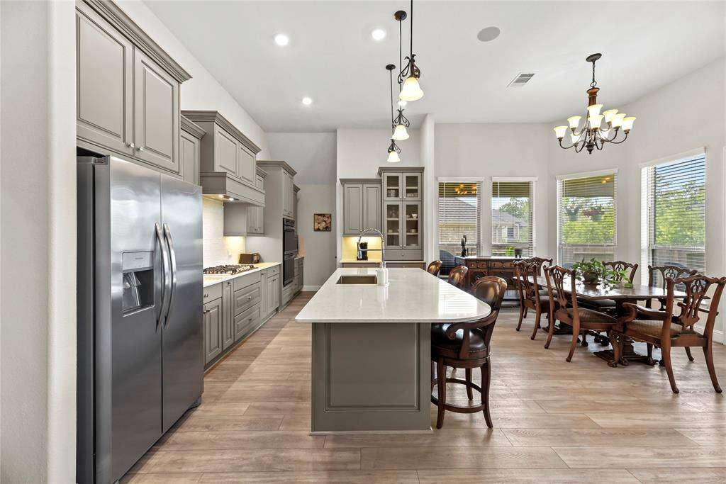 Your chef-inspired kitchen is ready to impress! This beautifully designed space boasts gleaming silestone countertops, designer glass tile backsplash, and sleek stainless steel appliances. The richly painted cabinetry, enhanced with updated hardware, is perfectly complemented by under-cabinet lighting, recessed lighting, and pendant lighting creating a bright and inviting ambiance.