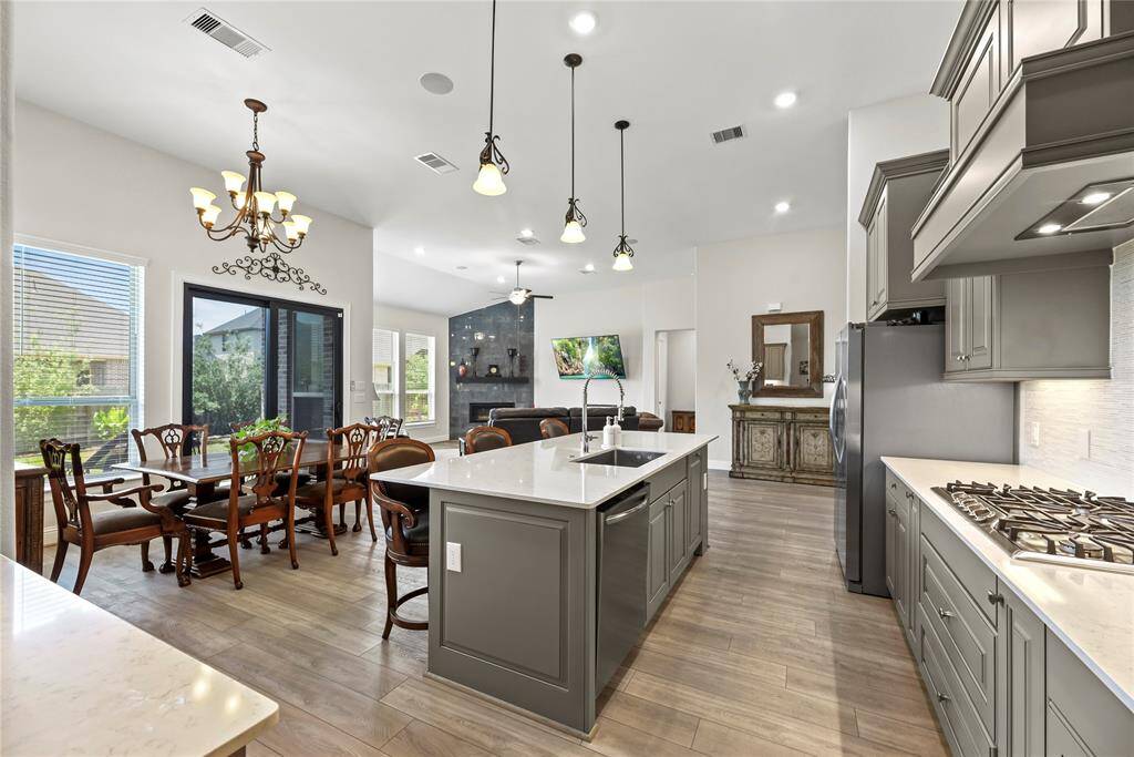Designer pendants spotlight the expansive island. Culinary dreams meet stylish reality.