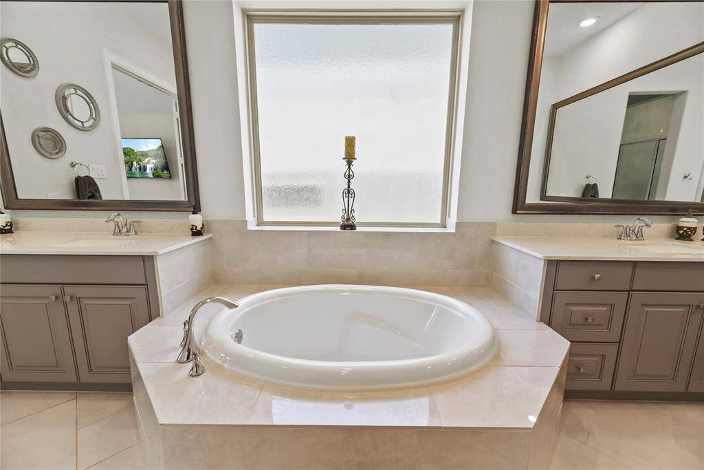 The primary bath boasts a luxurious deep soaking tub, offering the perfect retreat for relaxation and unwinding after a long day.
