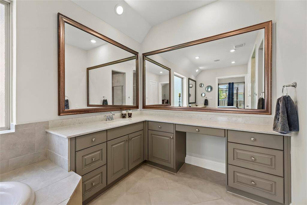 The vanity, masterfully designed with generous space for seating, offers an ideal spot to unwind while getting ready, combining functionality with comfort.