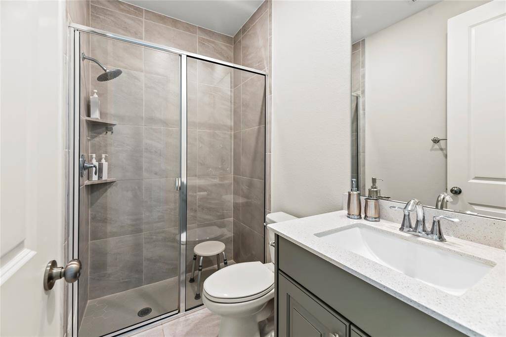 A second beautifully appointed bath provides a perfect retreat for family and guests, blending comfort and style with thoughtful details like the walk-in shower and vanity.