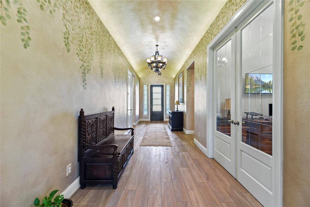 The elegant entryway flows seamlessly into a set of double glass doors on the left, that open to a sophisticated study, offering both style and privacy.
