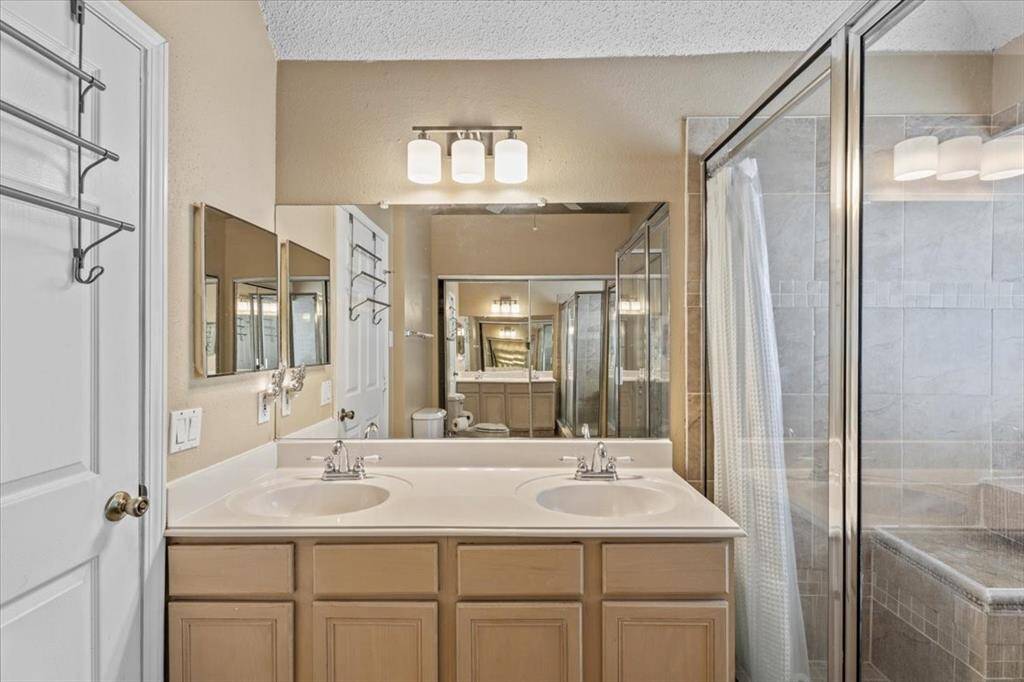 The primary bath features double sinks and a spacious walk-in shower, offering both comfort and convenience.