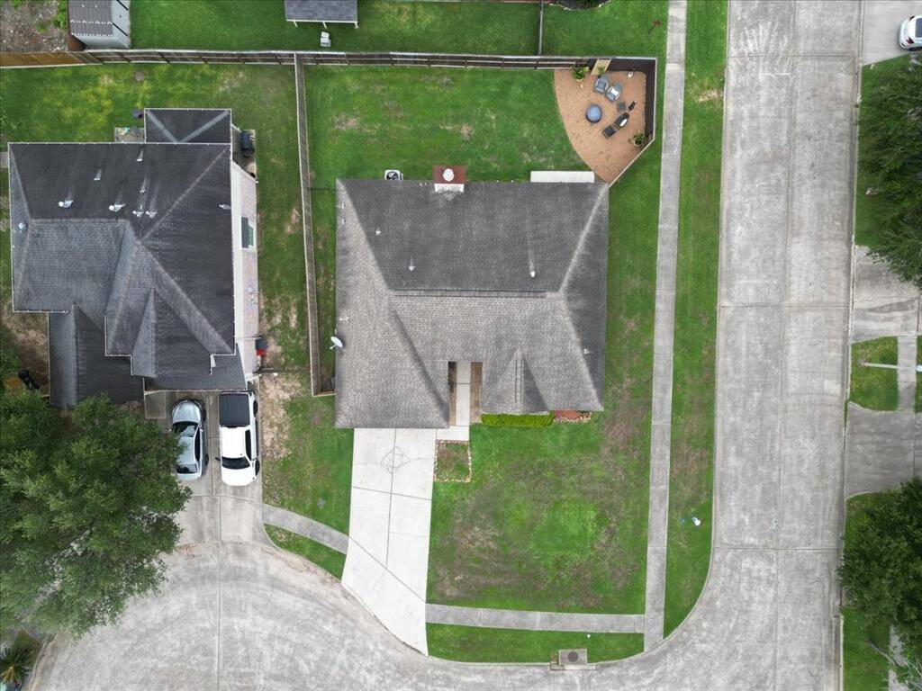 An aerial view showcases the home's charming curb appeal, expanded driveway, and corner lot location.