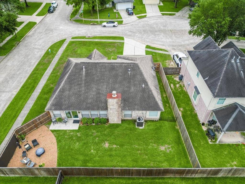 This aerial view of the backyard highlights the spacious, fully fenced yard—perfect for gatherings, play, and relaxation.