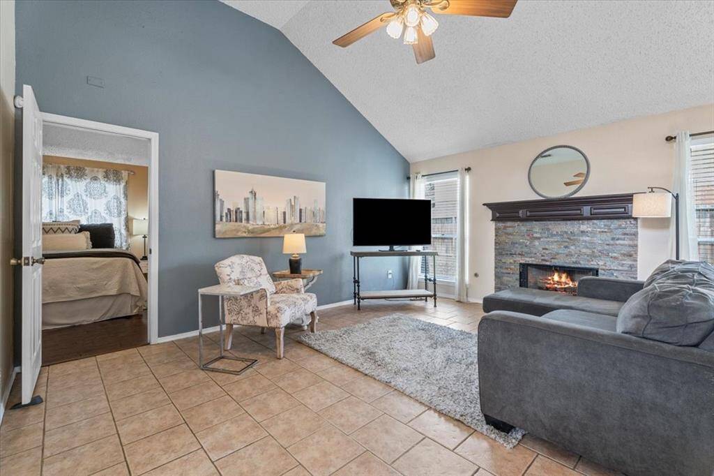 With its gas fireplace, vaulted ceilings, and streams of natural light, the living room is both elegant and inviting.