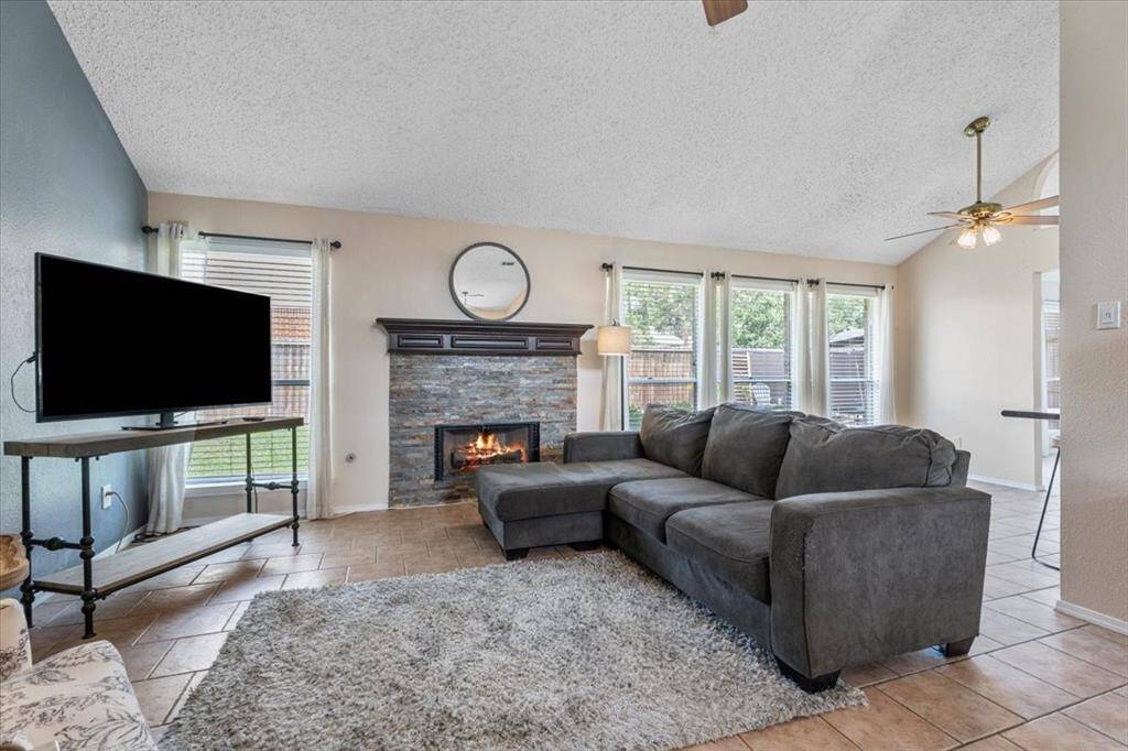 With its gas fireplace, vaulted ceilings, and streams of natural light, the living room is both elegant and inviting.
