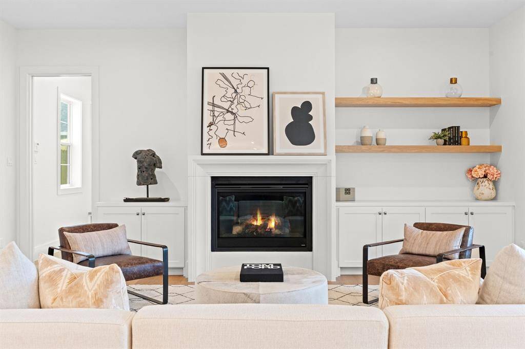 A cozy living space featuring a fireplace centerpiece and built-in shelving to display your personal style.