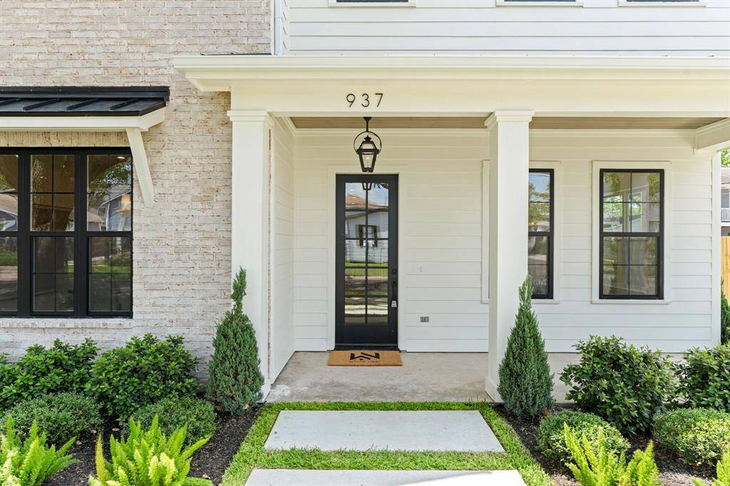 A warm welcome every time. The covered front entry is accented by classic lantern lighting, lush landscaping, and a sleek glass-panel front door.