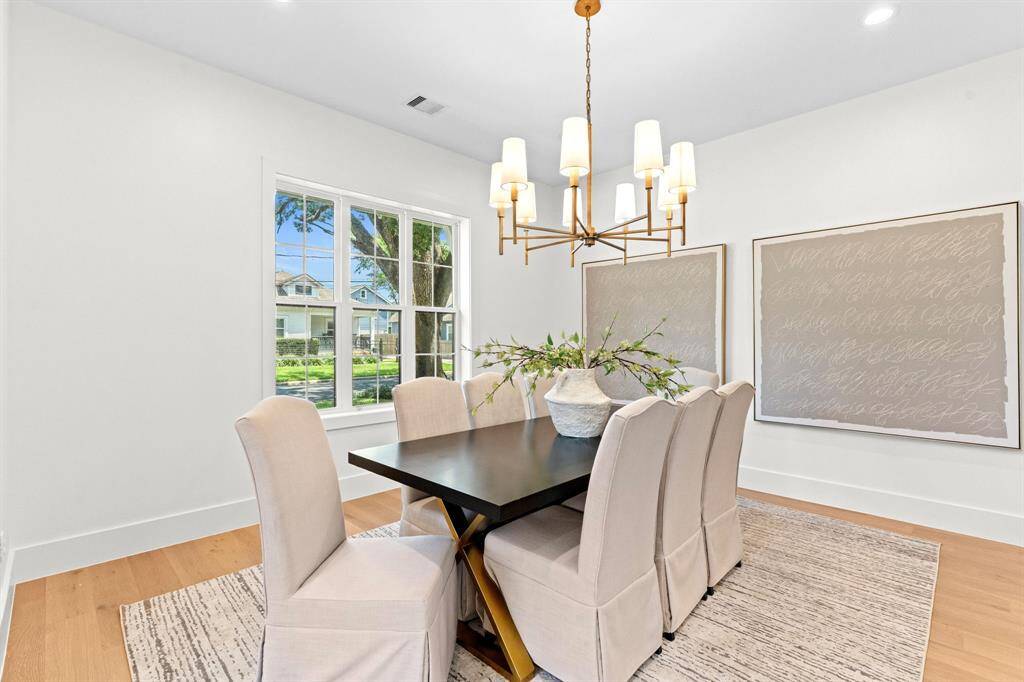 Framed by oversized windows, the dining room is bathed in natural light, with designer lighting that anchors the space in effortless sophistication.