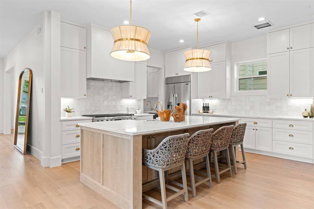 A showstopping kitchen with custom cabinetry, a stunning statement island, and top-tier appliances