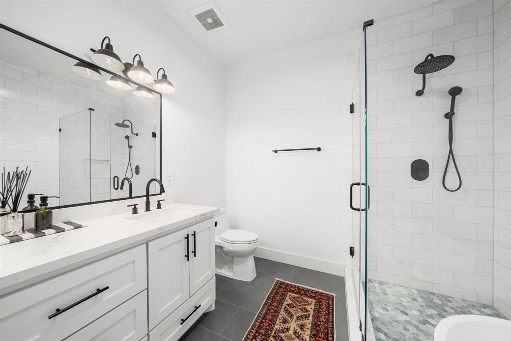 The remodeled primary suite offers 2 walk-in closets and an elegant en-suite bath.