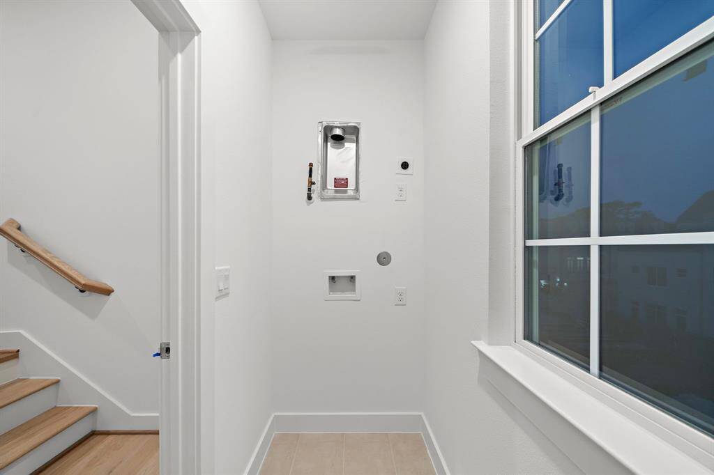 The laundry room is located between the second and third floor. This laundry room has a shelf, a hanging bar and a window.