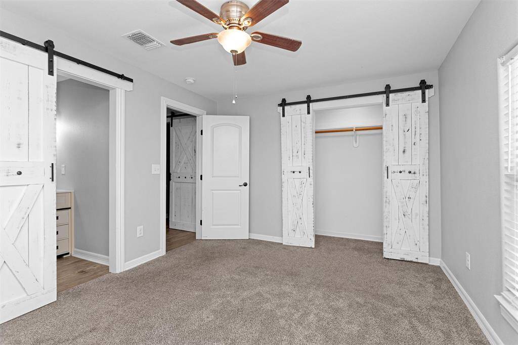 Master bedroom has custom built sliding barn doors to the closet and primary bath