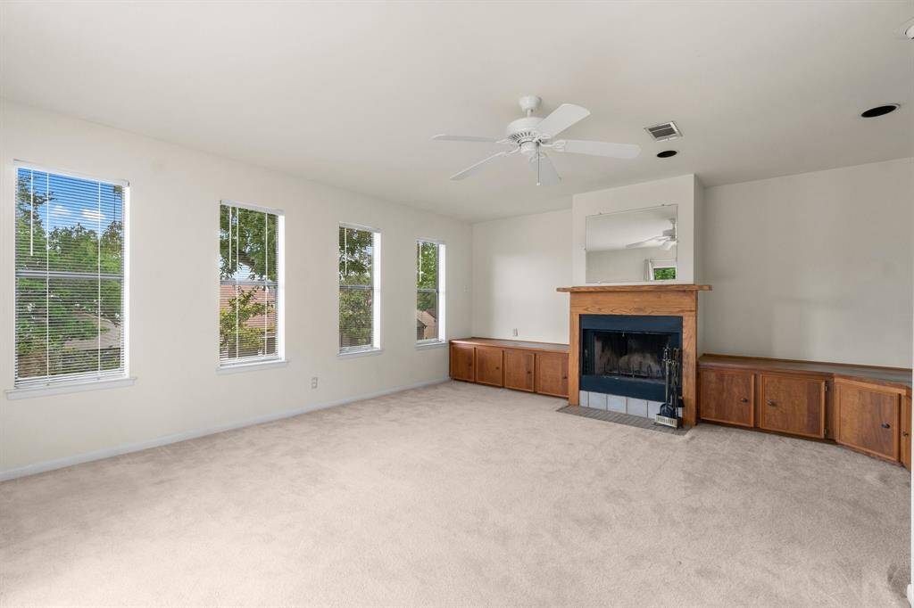 This cozy upstairs living area features a wood-burning fireplace.  Large windows let in tons of natural light.
