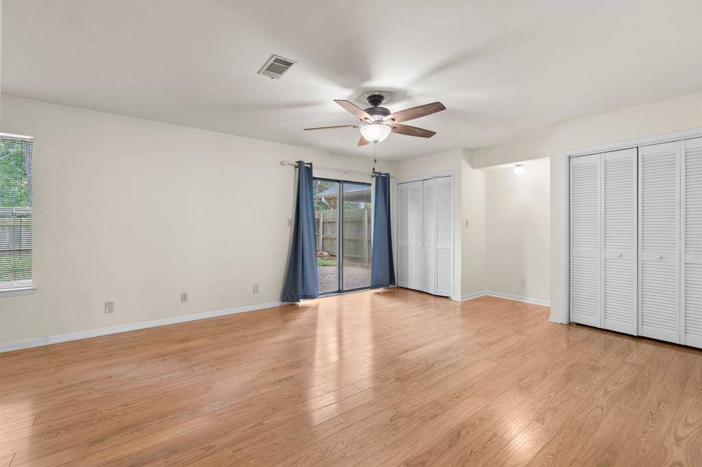 Primary Bedroom features views of the fenced backyard and access to back patio area.