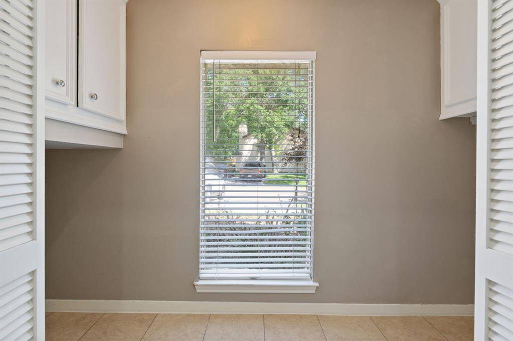Large UTILITY ROOM (looking out to the front yard) with lots of cabinet space and a window for natural light.