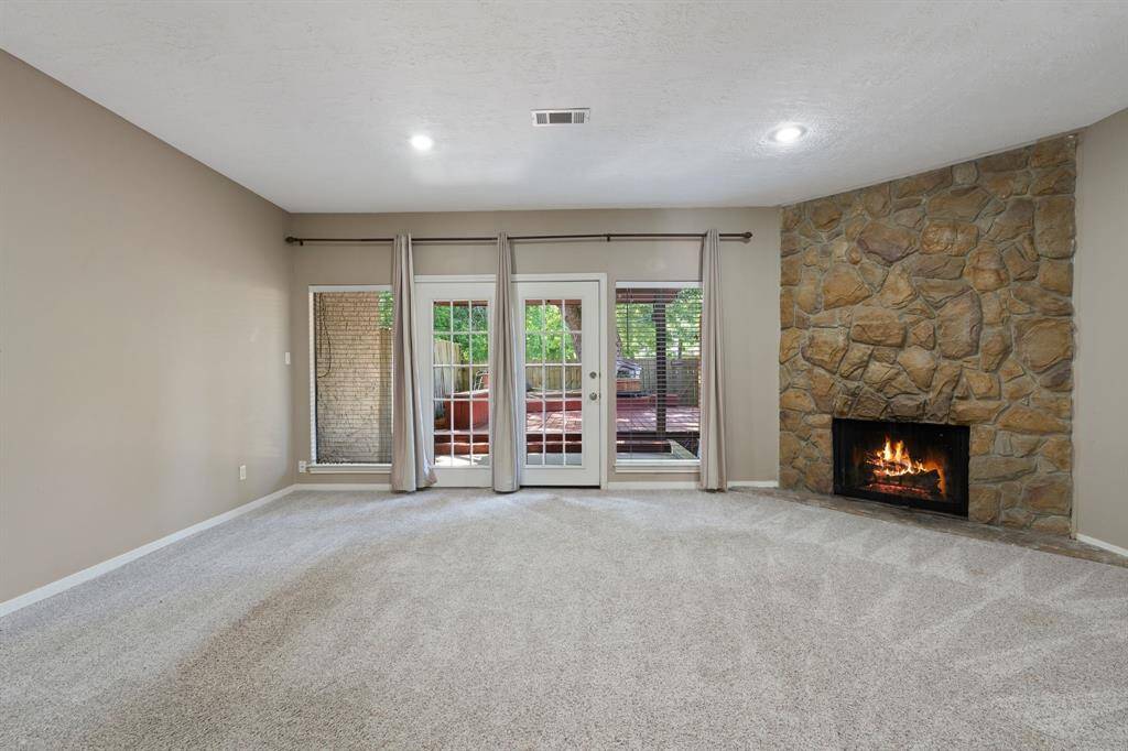 Spacious living area with striking STONE FIREPLACE.