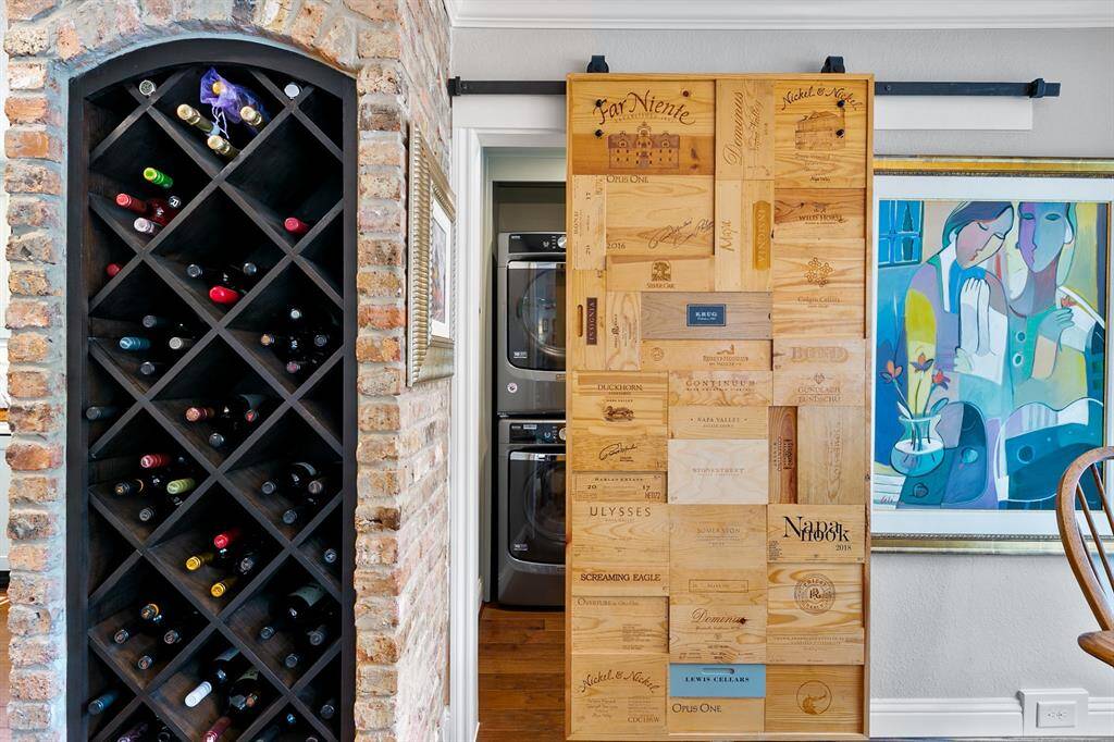 Lending a nod to the California wine country the dark wood wine rack beautifully contrasts with the brick encasement.  Laundry room is located on the other side of the sliding door.