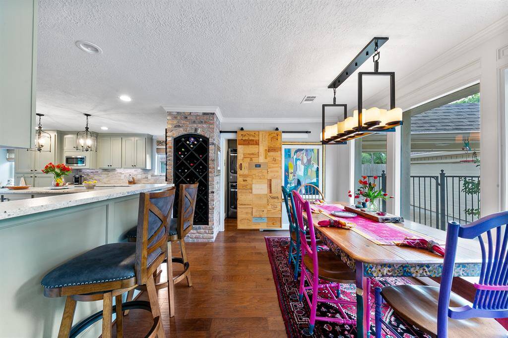 Sellers turned to classic inspiration for the candelabra lighting over the dining table. It truly looks like candle light with its depth and dimension. Note another seating area that accommodates bar seating.