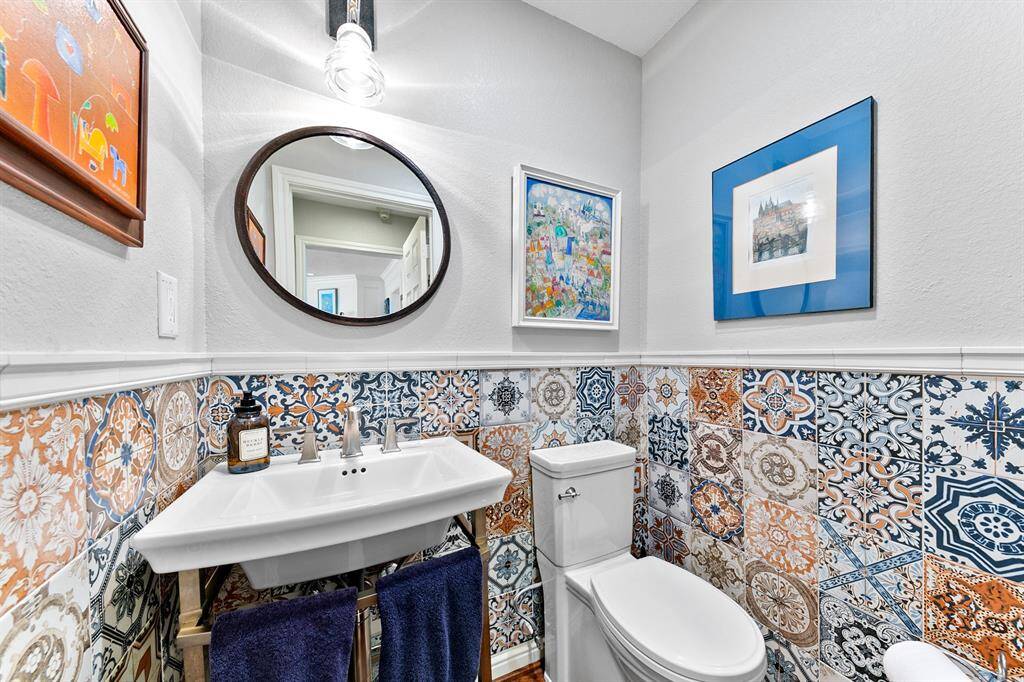 To keep things friendly and fun in this half bath, Sellers chose this free standing Victorian-inspired basin and custom-selected patterned wall tiles!