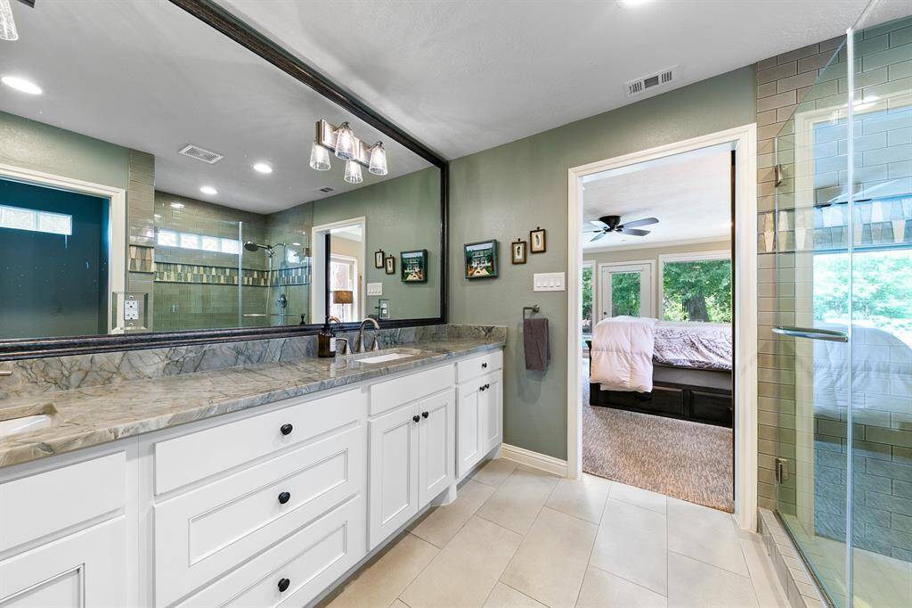 Marble counters with double drop-in sinks, custom cabinetry and gorgeous framed mirror.