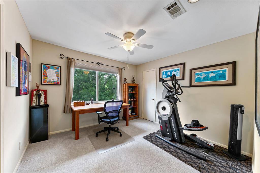Another guest bedroom that was being utilized as a study features lovely backyard views.