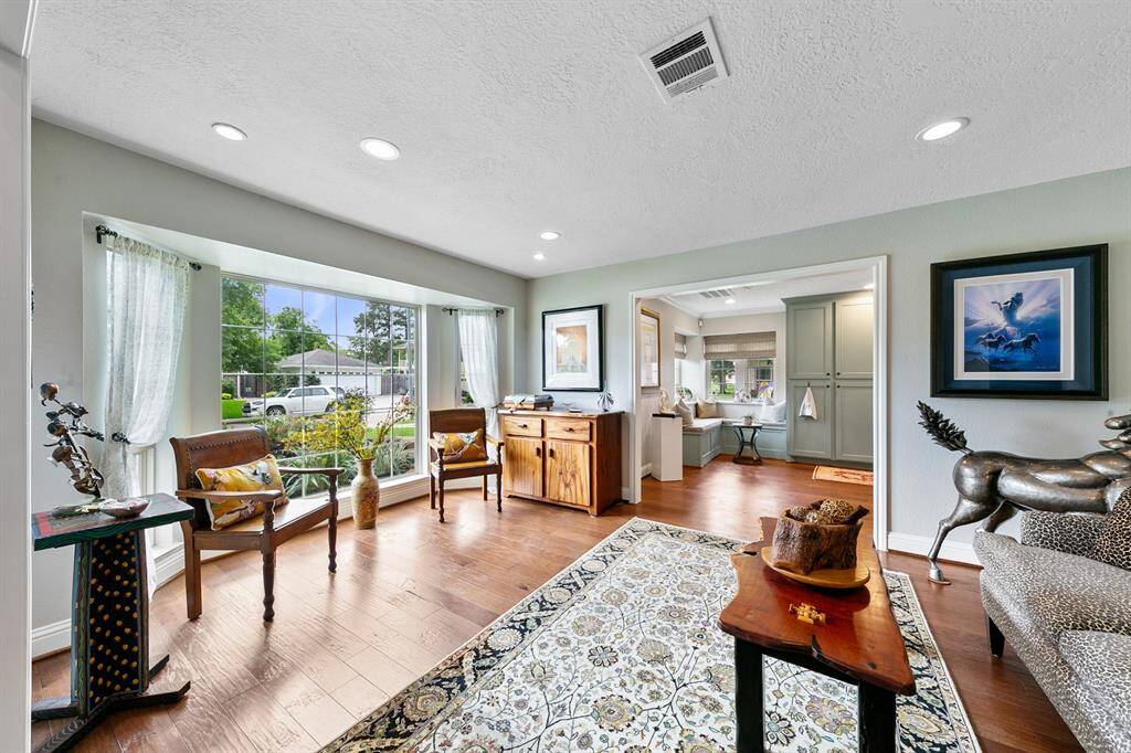 A front living room flooded with natural light through charming paned windows.