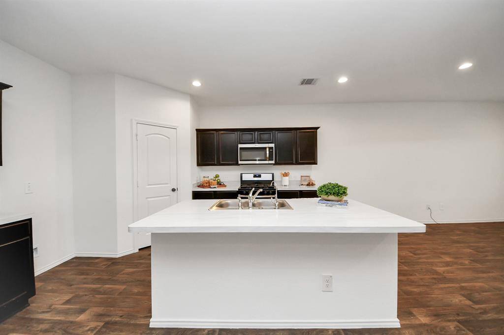 This room features neutral carpeting and white walls, offering a clean and bright space. It includes a door leading to a hallway or adjacent area, suitable for a bedroom or office.