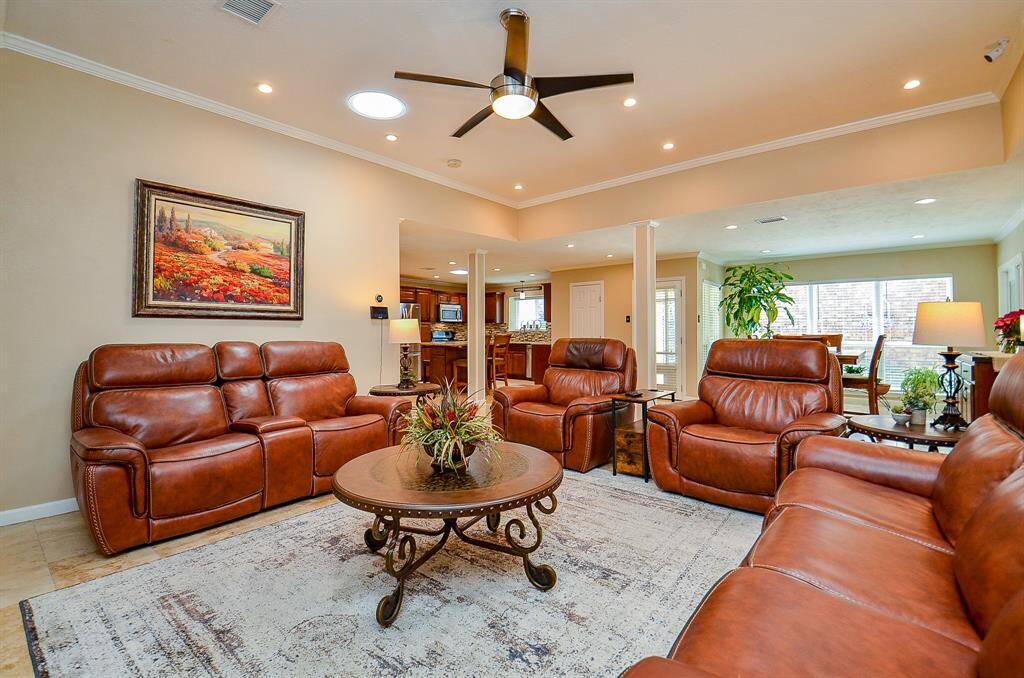 Spacious, open and bright living room leads to a dining area with large windows, creating a bright and inviting atmosphere.