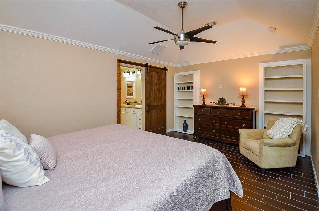 Primary suite includes built-in book shelves and an attractive sliding, wood door that opens to the fabulous primary bath.