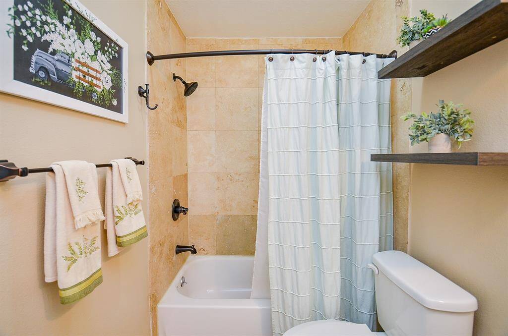 Second full bathroom features a tiled shower with modern fixtures.