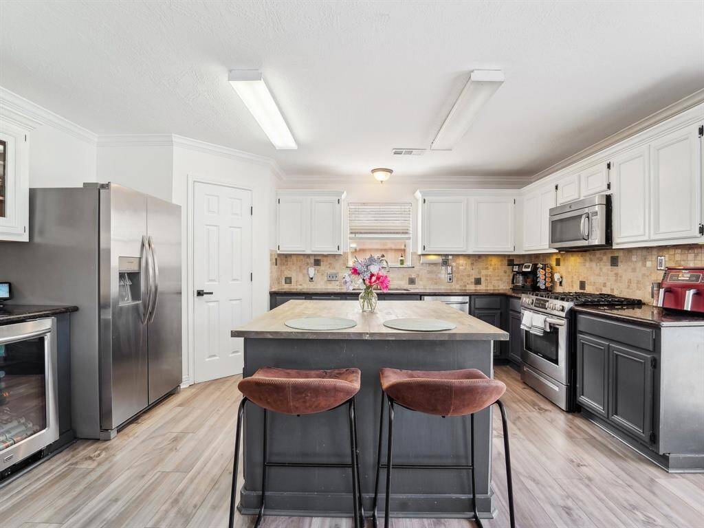 Take a look at the abundance of cabinetry and granite counter space! And don't overlook that beverage chiller, it's stays with the home!