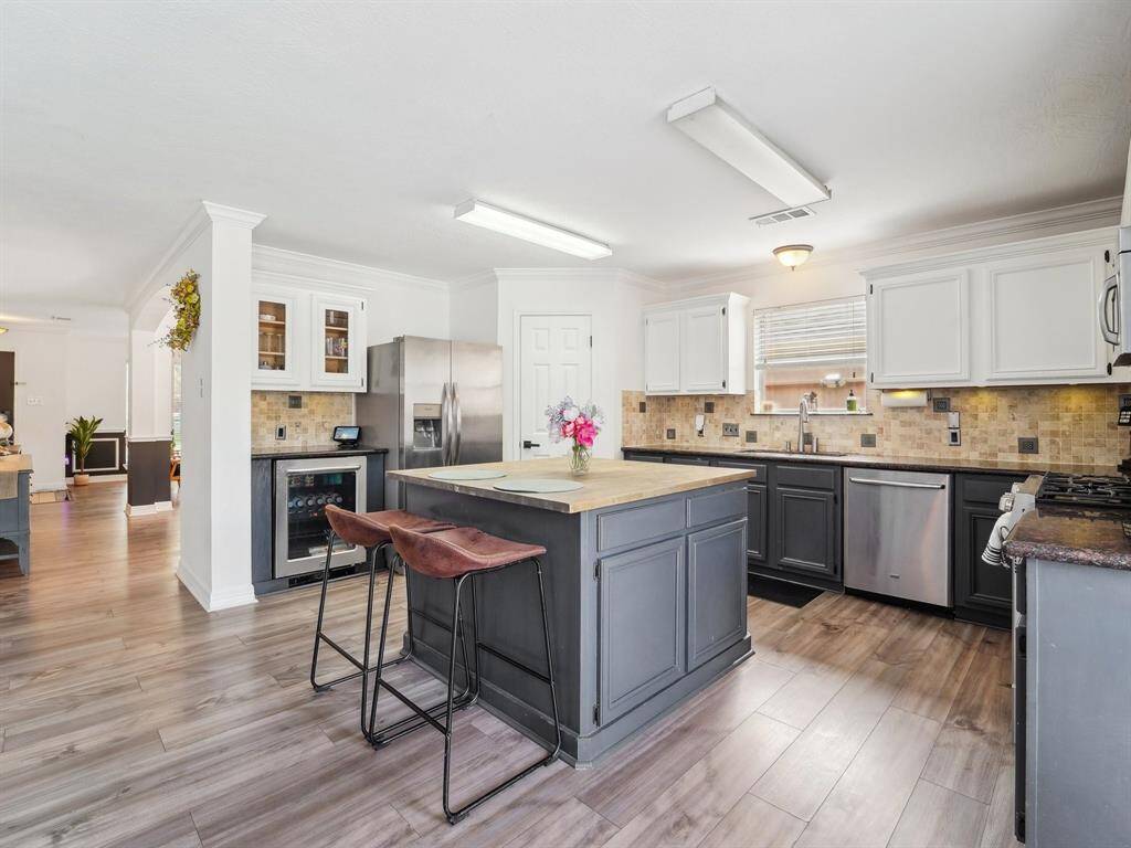 The huge island is adorned with a butcher block counter and has breakfast bar seating.