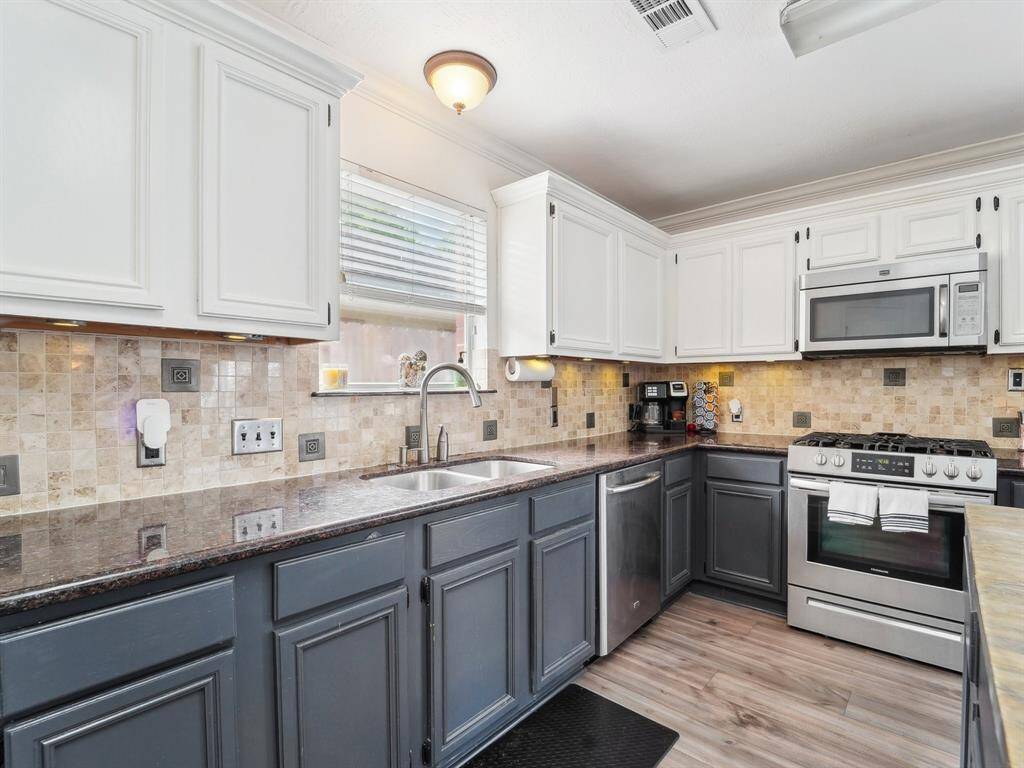 You'll love the two toned cabinetry and tiled backsplash with pretty, decorative inlay. And of course, who doesn't love a gas range?!