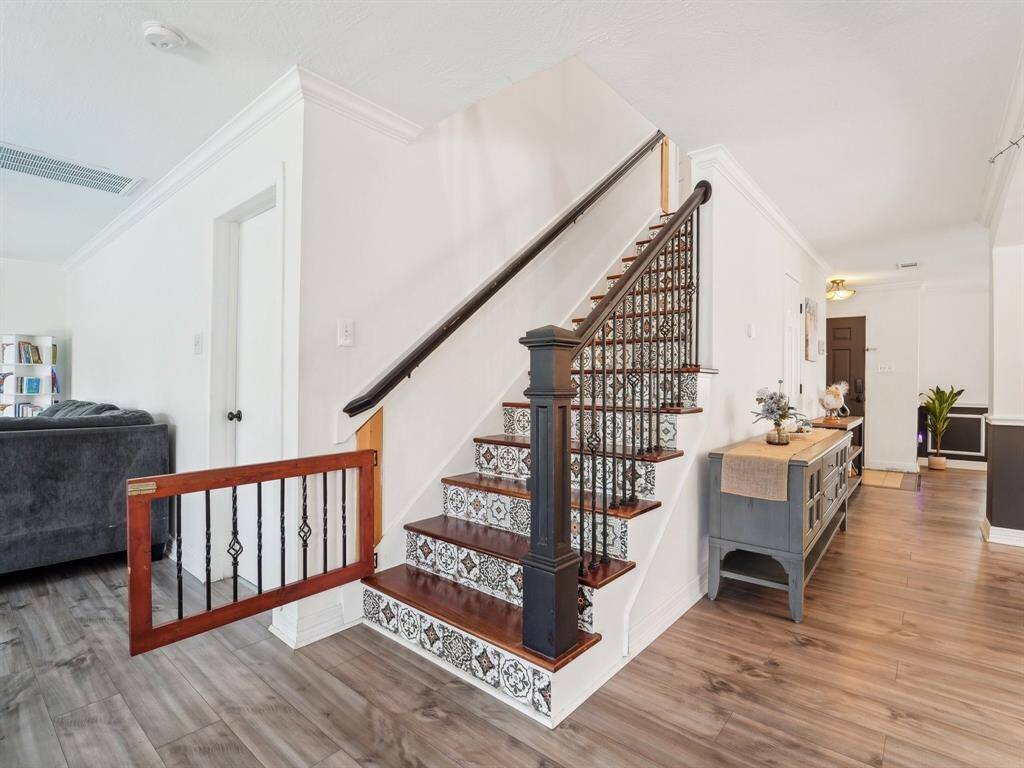 Heading upstairs, you'll notice this home has a gate to keep pets or little ones from going up the stairs. Also take a look at the wood stair treads and cool tile risers!