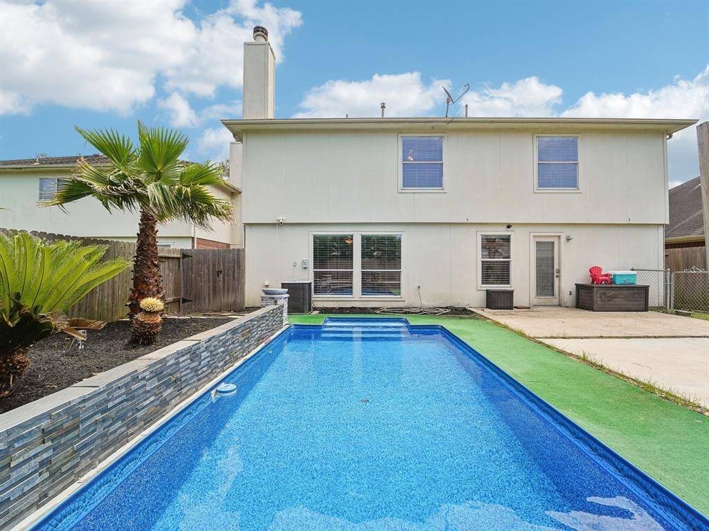 Pretty pool with decorative wall and palm trees!