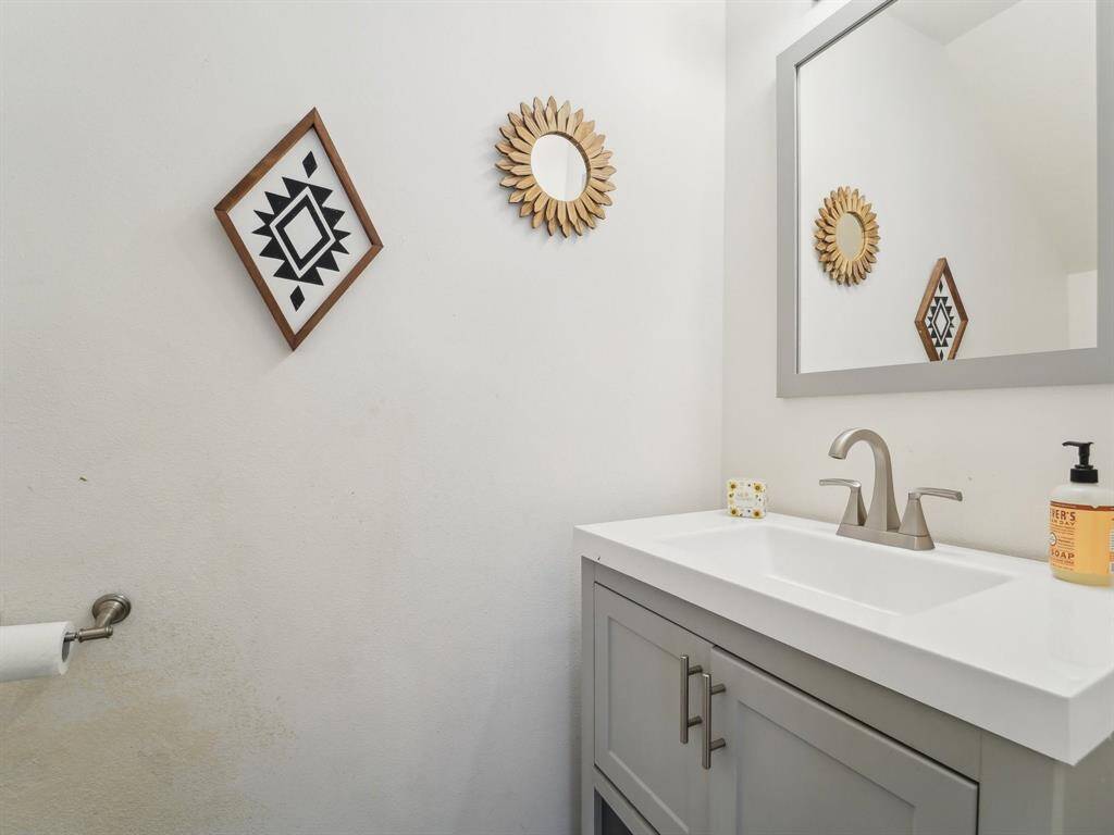 The half bath is located off of the Formal Living and Formal Dining. It's been updated with cabinetry & sink, and pretty tile flooring.