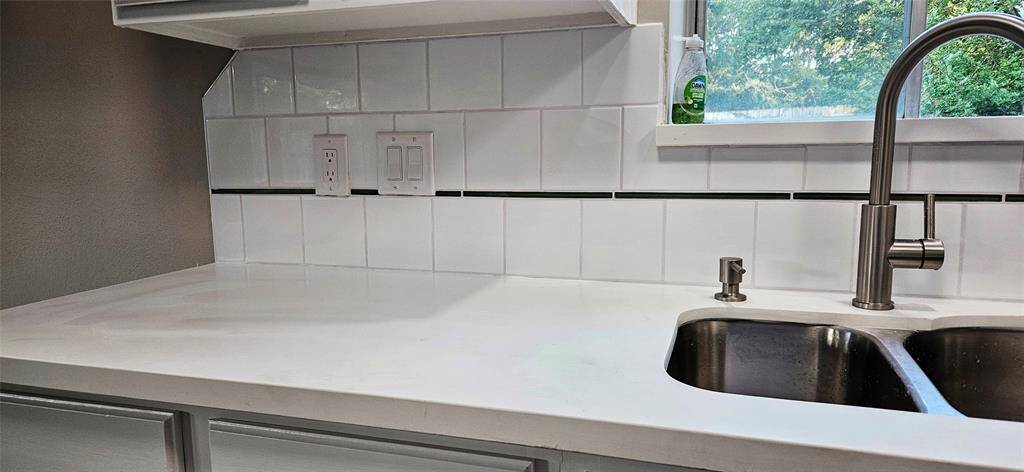 Kitchen is slightly open to Den with Quartz Counters, New D/W, and Microwave. Deep SS Sink and Brush Nichol pull down Faucet.