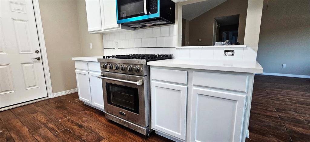 Kitchen is slightly open to Den with Quartz Counters, New D/W, and Microwave. Deep SS Sink and Brush Nichol pull down Faucet.