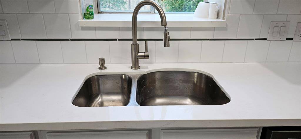 Kitchen is slightly open to Den with Quartz Counters, New D/W, and Microwave. Deep SS Sink and Brush Nichol pull down Faucet.