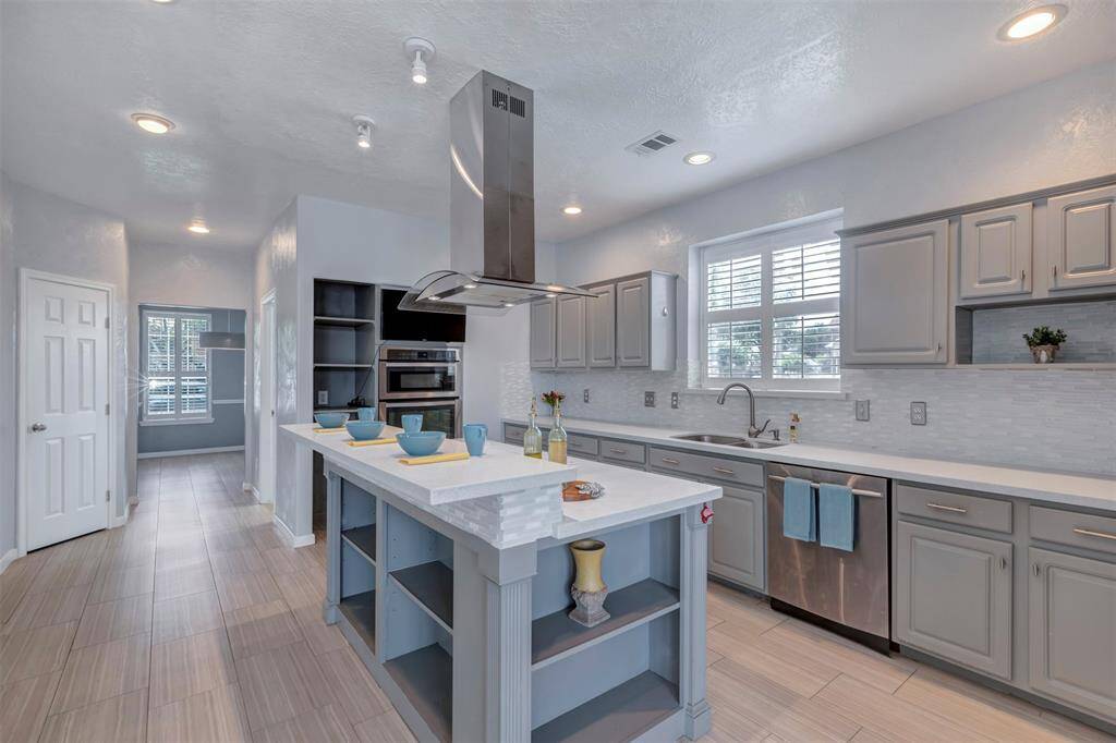 The beautifully updated kitchen offers an island with cooktop, breakfast bar and ample cabinet and counter space.