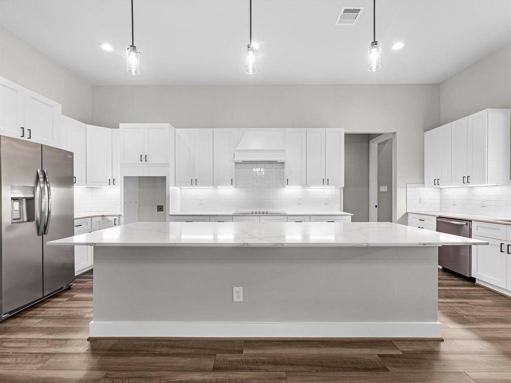 This elegant kitchen is anchored by the large island, topped with white quartz
