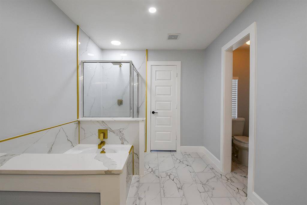 Primary bathroom featuring beautiful marble-look tile floors!