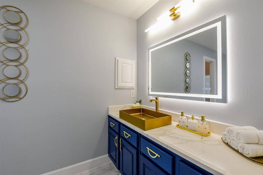 Quartz counters and a modern LED bathroom mirror in the primary bathroom!