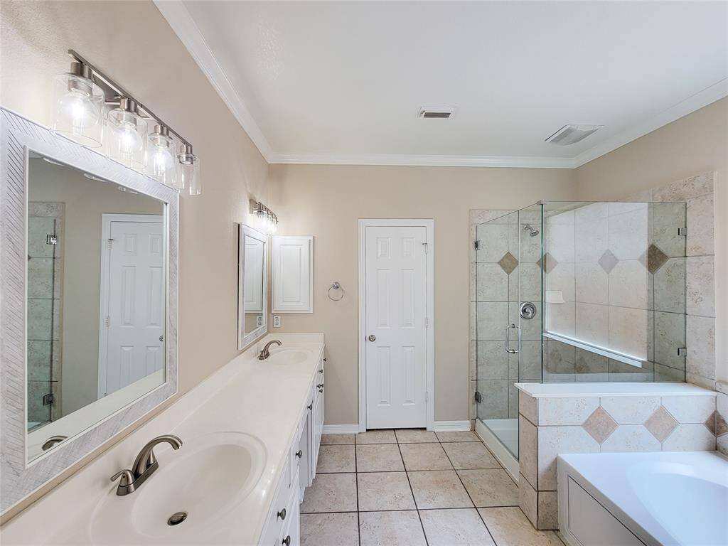 Updated Primary Bathroom! Note the New seam-less glass shower door, new light fixtures/ faucets, new mirrors.