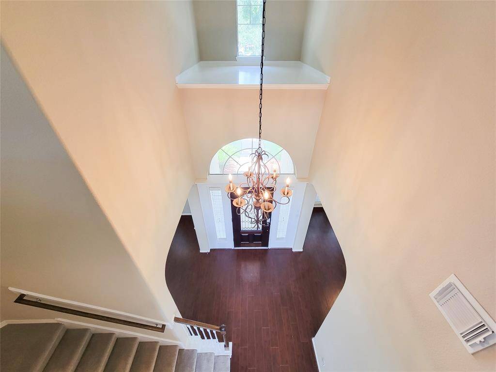 View of Foyer from second floor. Updated light fixtures. Note the space above the doorway for your art display or nick-nacks..