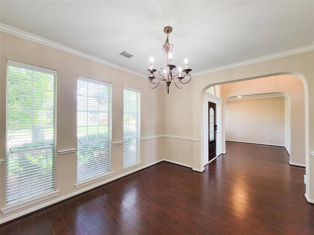 Charming Formal Dining with laminated wood floor & crown moldings.