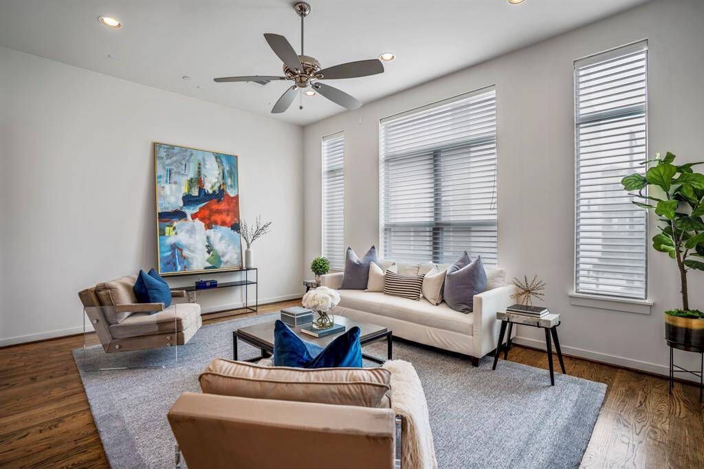 The living room features a wall of windows providing an abundance of natural light.