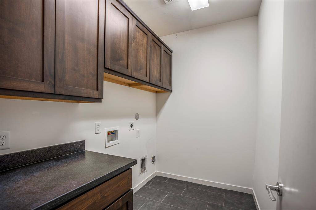 Spacious utility room is located at the top of the stairs on the third floor and features an abundance of storage and a large counter for easy folding. Electric and gas connections are provided for the dryer.